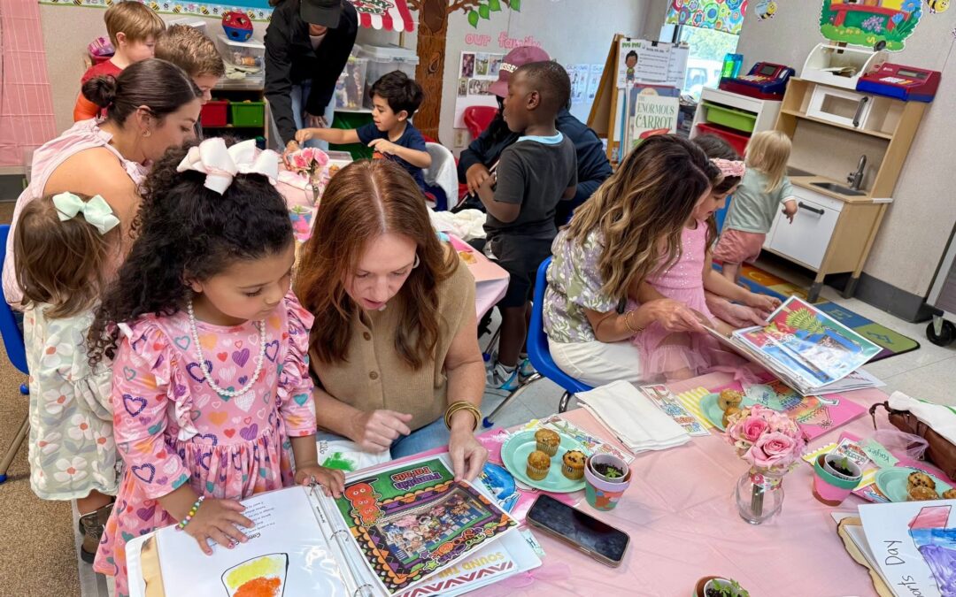 Parents and children reviewing keepsake books in preschool classroom